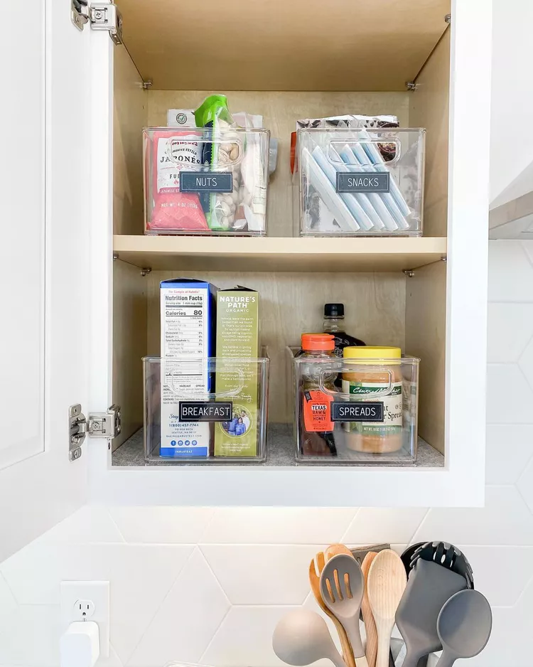 an organized pantry with labelled baskets