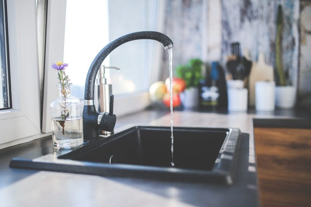 Tap water flowing in Black sink